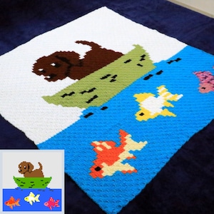 May include: A crocheted blanket with a brown dog in a green boat on a blue background with orange, yellow, and pink fish. The blanket is made with a textured stitch.