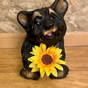 Wood carved black bear with sunflower chainsaw art.