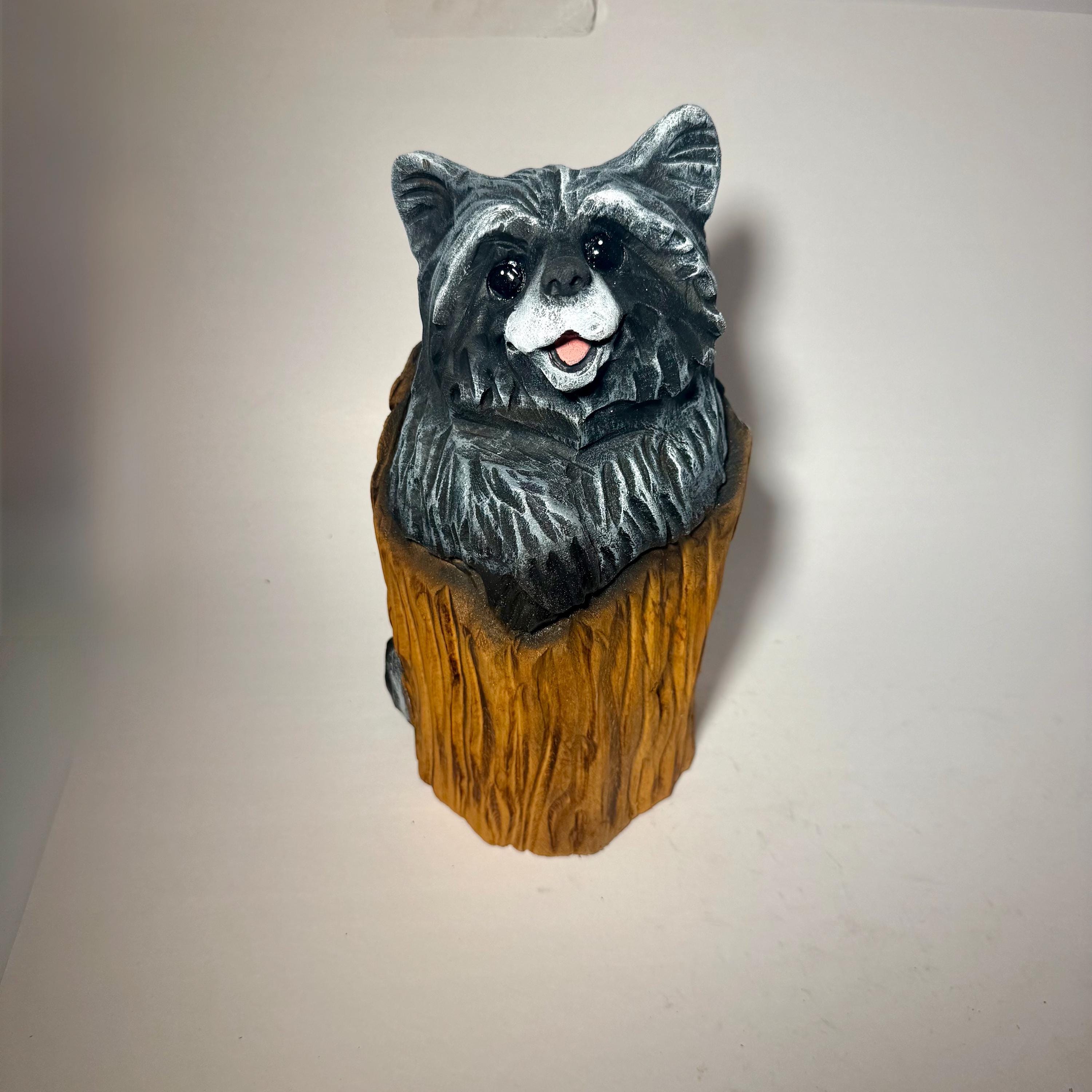 切り株に彫られたキュートなチェーンソー彫りのアライグマ。素朴な