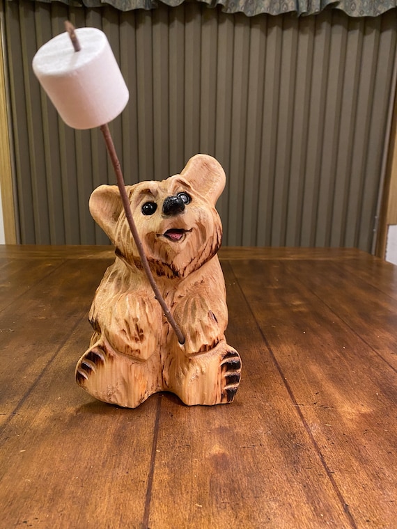 チェーンソーで彫られたマシュマロ付きのクマ。ウェルカムベア