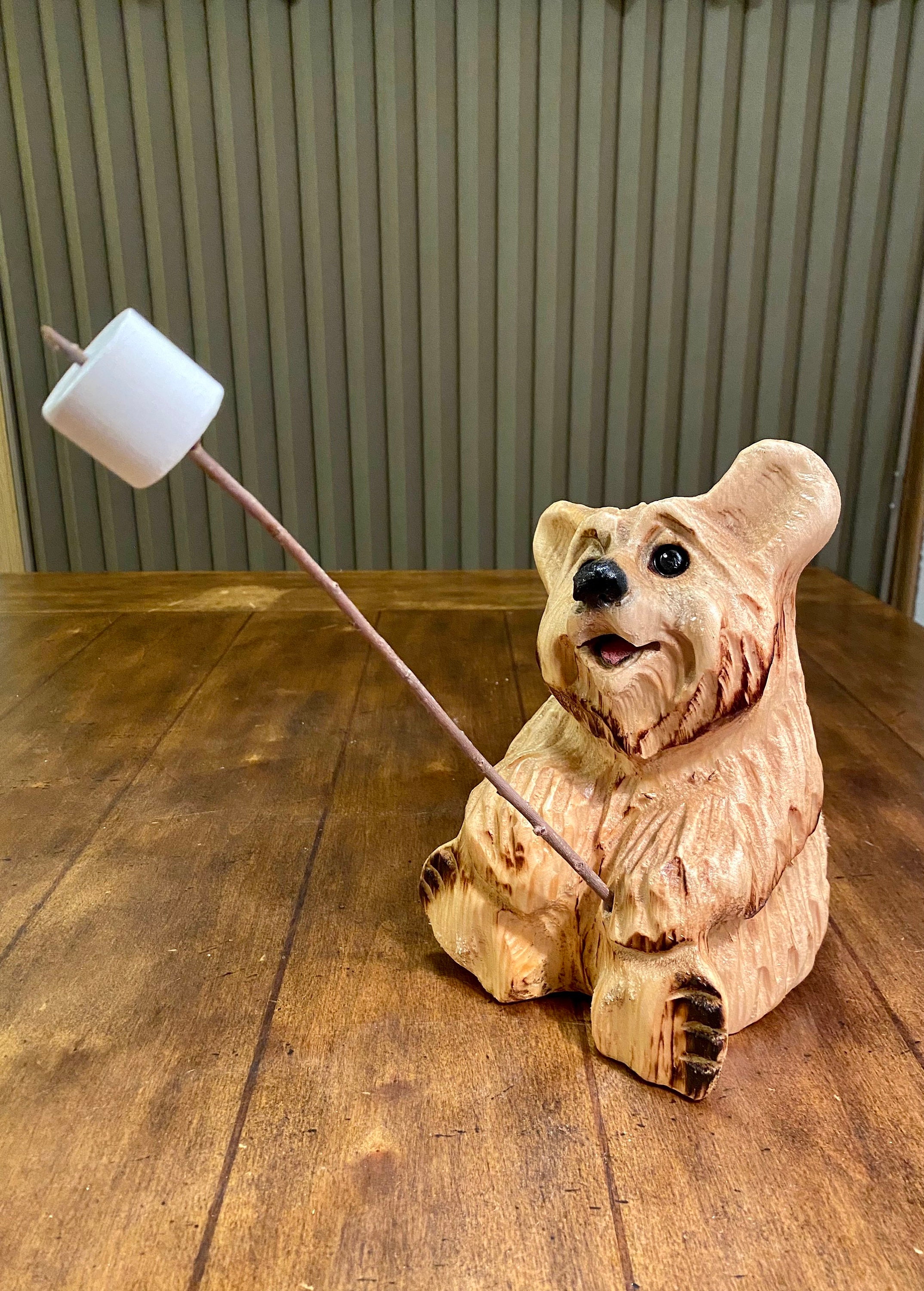 チェーンソーで彫られたマシュマロ付きのクマ。ウェルカムベア