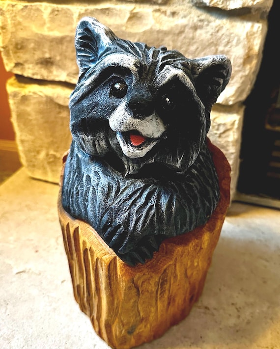 切り株に彫られたキュートなチェーンソー彫りのアライグマ。素朴な