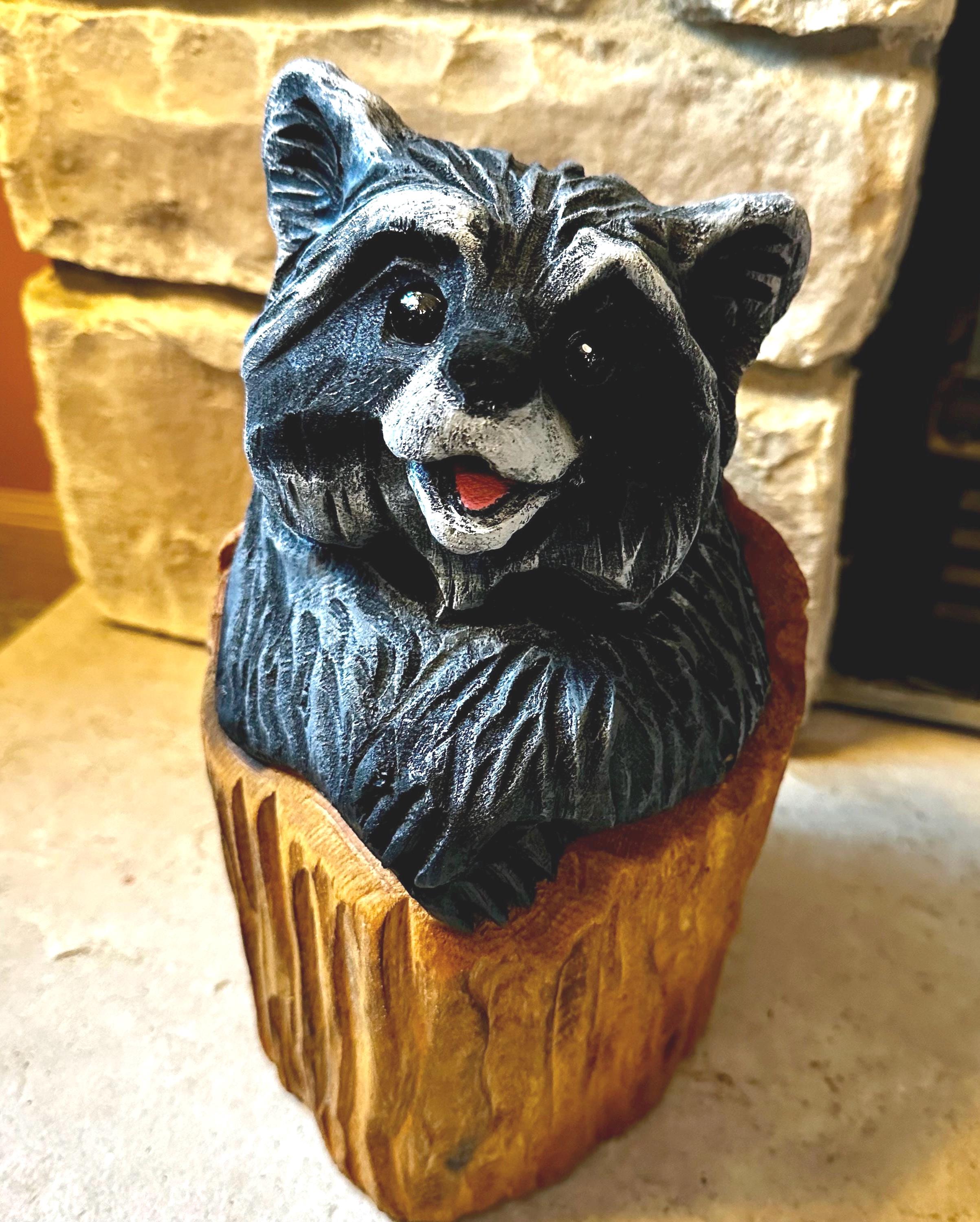 切り株に彫られたキュートなチェーンソー彫りのアライグマ。素朴な