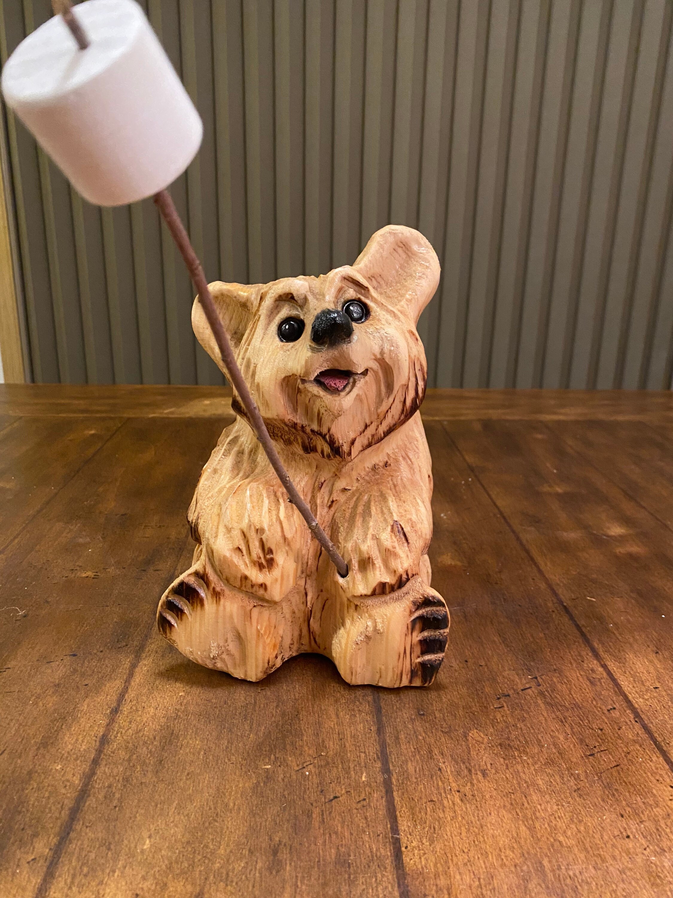 チェーンソーで彫られたマシュマロ付きのクマ。ウェルカムベア