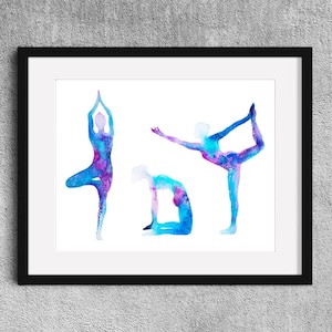 Könnte beinhalten: Gerahmter Aquarelldruck mit drei Yoga-Posen in Blau- und Lilatönen. Die Figuren sind vor einem weißen Hintergrund in einem schwarzen Rahmen dargestellt. Das Kunstwerk zeigt eine Baum-Pose, eine Tänzer-Pose und eine sitzende Vorbeuge.