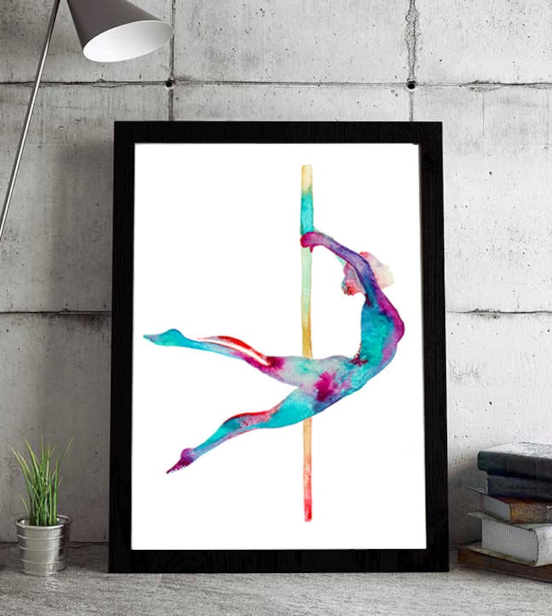 May include: A framed watercolor print featuring a figure in motion on a pole. The artwork uses vibrant colors, including teal, pink, and purple, to depict a dancer. The pole is a light brown color. The frame is black.