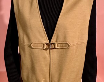 May include: A tan vest with a V-neck and two sets of gold buckles. The vest is made of a soft, textured fabric.