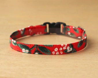 May include: Red and green floral patterned dog collar with a black plastic buckle.