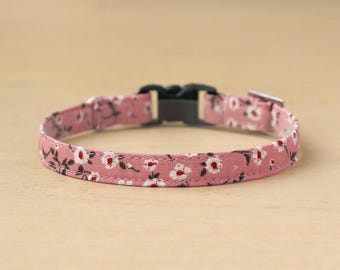Könnte beinhalten: Ein pinkfarbenes Hundehalsband mit floralem Muster und einer schwarzen Schnalle.