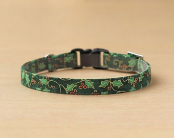 May include: A green and gold Christmas-themed cat collar with a holly pattern.