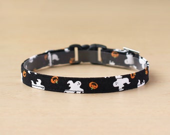 May include: Black adjustable dog collar with a Halloween-themed print featuring white ghosts and orange pumpkins.
