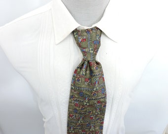 May include: Olive green necktie with a repeating pattern of floral and geometric shapes in red, blue, and gold. The tie is knotted and worn with a white dress shirt. The tie's design is visible.