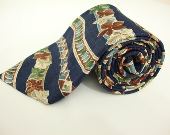 May include: Rolled navy blue tie with a repeating pattern of leaves and geometric shapes in shades of brown, green, and beige. The tie is made of a smooth fabric and is rolled up, showing the pattern in detail.