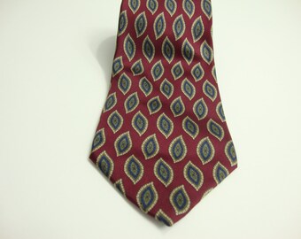 May include: A burgundy tie with a repeating pattern of olive green and navy blue teardrop shapes. The tie is made of a smooth fabric and is displayed against a white background. The tie is a classic accessory.