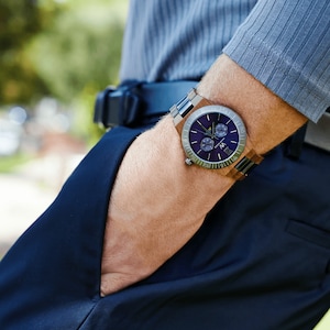 May include: A wristwatch with a brown wooden band and a blue face. The watch has a silver-toned bezel and a date window at the 3 o'clock position.