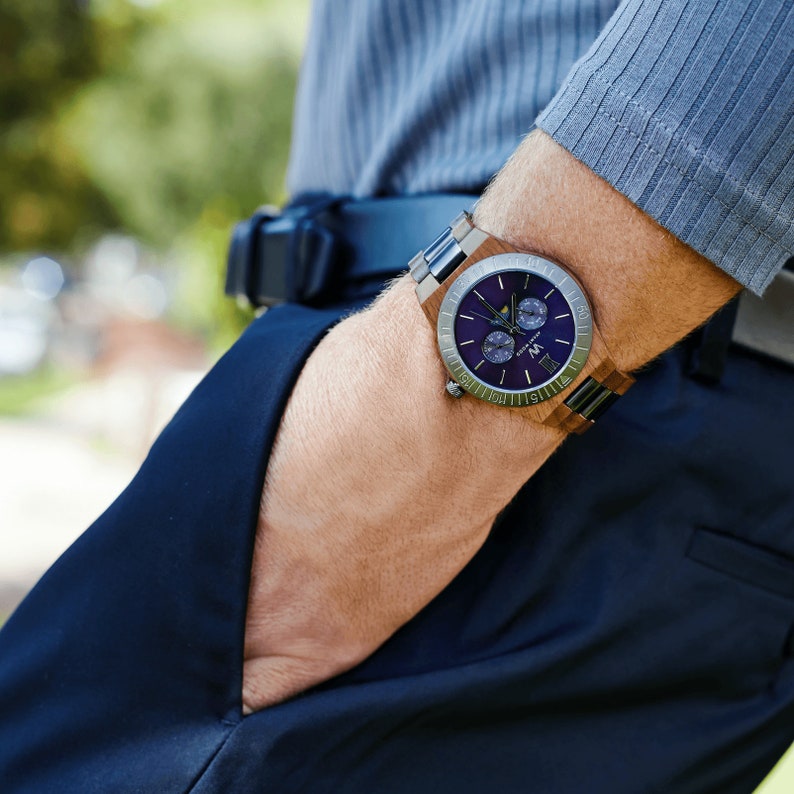 May include: A wristwatch with a brown wooden band and a blue face. The watch has a silver-toned bezel and a date window at the 3 o'clock position.