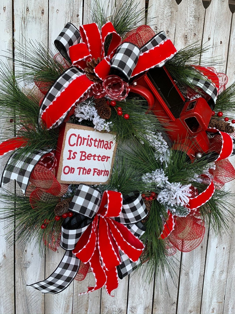 May include: A Christmas wreath with red and black buffalo plaid ribbon, a red truck, and a sign that reads "Christmas Is Better On The Farm".