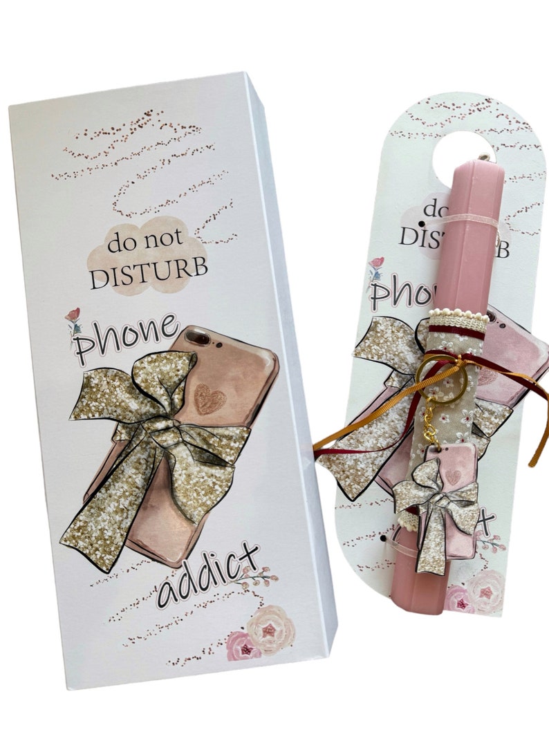 K&ouml;nnte beinhalten: Eine wei&szlig;e Schachtel und ein rosa T&uuml;rh&auml;nger mit einem Telefon-Thema. Die Schachtel hat eine Zeichnung eines Telefons mit einer goldenen Schleife und den Worten "do not DISTURB Phone addict". Der T&uuml;rh&auml;nger hat einen rosa lippenstiftf&ouml;rmigen Gegenstand mit einem Telefonanh&auml;nger.