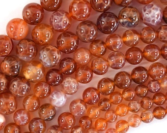 May include: A strand of round, orange agate beads with a translucent, marbled pattern. The beads are approximately 10mm in diameter.
