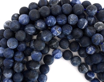 May include: A strand of dark blue, round, smooth, natural gemstone beads. The beads have a mottled, marbled appearance with white and light blue streaks.