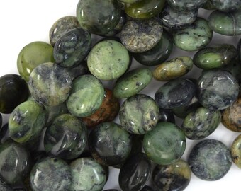 Könnte beinhalten: Eine Ansammlung polierter, flacher, grüner Steine mit unterschiedlichen Farbtönen und Mustern. Die Steine reichen von hell- bis dunkelgrün, wobei einige schwarze Aderungen aufweisen. Die glatten, abgerundeten Formen deuten darauf hin, dass sie getrommelt oder geformt wurden.