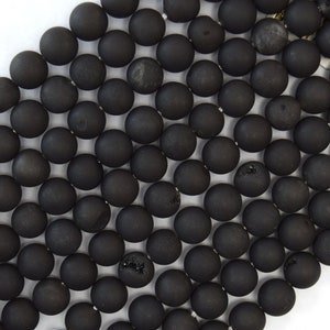 May include: A strand of black agate beads, each bead is round and smooth with a matte finish.