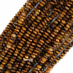 May include: Strands of faceted tiger eye gemstone beads. The beads are a mix of brown and gold tones, with a polished, reflective surface. The beads are approximately 2x4mm in size.