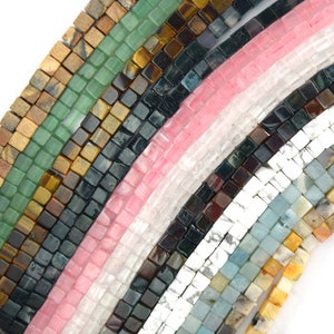 Pode incluir: Conjunto de contas quadradas de pedras preciosas em várias cores, incluindo verde, marrom, rosa, preto, branco e azul. As contas são dispostas em filas, criando um padrão colorido e texturizado.