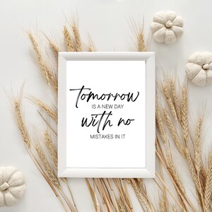 May include: A white framed print with the text "Tomorrow is a new day with no mistakes in it" in black script. The print is surrounded by wheat stalks and small white pumpkins on a white background.