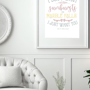 Peut inclure: Impression encadrée avec la citation "I DON'T WANT sunbursts OR MARBLE HALLS I JUST WANT YOU" dans une police décorative. L'impression est dans un cadre blanc et est accrochée à un mur blanc. La citation est tirée d'"Anne of Green Gables".
