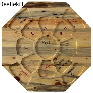 May include: A wooden octagonal game board with a central circle labeled "Pot". The board has eight sections, each labeled with a suit of cards: Hearts, Diamonds, Clubs, Spades, Kitty, 8-9-10 All In One, QK, and 10. The board is made of light wood with a blue and brown grain pattern.
