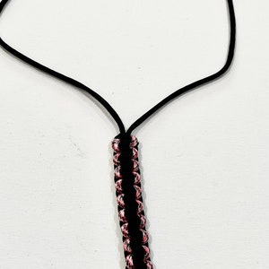 K&ouml;nnte beinhalten: Ein schwarzes Lanyard mit einem pinkfarbenen und schwarzen Paracord-Knoten und einem silbernen Schl&uuml;sselring.