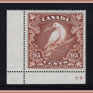 Puede incluir: Un sello postal canadiense que representa una paloma blanca posada en una rama, sosteniendo una ramita. El sello está enmarcado por adornos ornamentales y la palabra "CANADA" en la parte superior. El valor es "95 CENTS", con los años "1999" y "2000" visibles.
