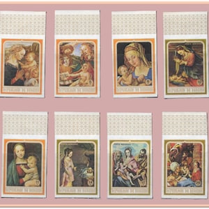 Op de afbeelding: Een verzameling van acht vintage lucifersdoosjes, elk met een religieus schilderij in een oranje rand. De kunstwerken tonen scènes met figuren in verschillende kleuren, waaronder blauw, rood en goud. De doosjes hebben een beige patroon.