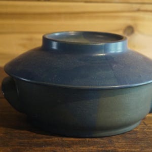 May include: A blue ceramic serving dish with a lid. The dish has a mottled blue and green glaze.