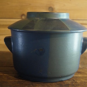 May include: A blue and green ceramic pot with two handles and a lid. The pot has a striped design.