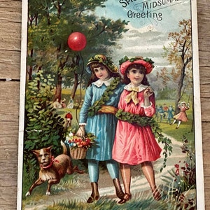 May include: A vintage postcard featuring two girls in dresses walking down a path with a dog. The girls are wearing floral wreaths and one is holding a basket of flowers. The postcard has the text "The Woolson Spice Co.'s Midsummer Greeting" at the top.