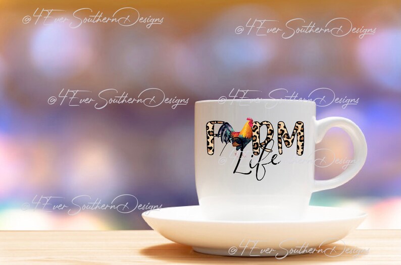 May include: A white ceramic mug and saucer set. The mug features the words "FARM LIFE" with a rooster illustration. The letters "FARM" have a leopard print design. The background is blurred with shades of purple and yellow.