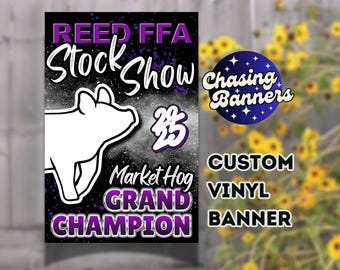 May include: Custom vinyl banner with a black and white background, featuring text in white and purple. The banner reads "REED FFA Stock Show 23 Market Hog GRAND CHAMPION" with a white outline of a pig. A blue circle with stars and the text "Chasing Banners" is also present.