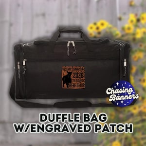 May include: Black duffle bag with an engraved patch featuring a silhouette of a cow and the text "RESERVE CHAMPION 2026 TRI COUNTY BEEF CLUB." The bag has a top handle, shoulder strap, and side zippers. The words "DUFFLE BAG W/ENGRAVED PATCH" are at the bottom.