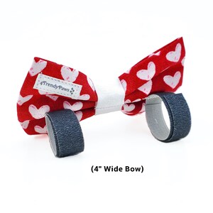 May include: Red bow tie with white hearts and a white centre, featuring adjustable velcro straps. The bow tie is 4 inches wide and has a "4TrendyPaws" label.