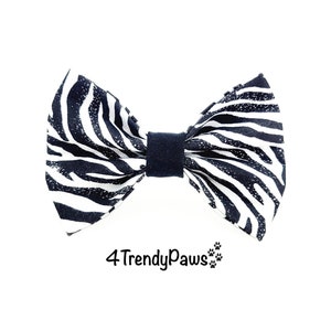 May include: Black and white zebra print bow tie with a black adjustable strap. 4TrendyPaws.