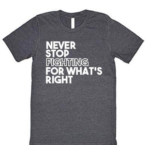 May include: Dark grey t-shirt with white text that reads "NEVER STOP FIGHTING FOR WHAT'S RIGHT".