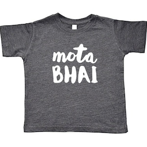 May include: Dark gray toddler t-shirt with the white text "mota BHAI" across the front. The shirt has short sleeves and a crew neck. The fabric has a heathered texture.