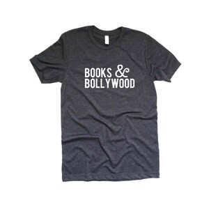 May include: Dark gray t-shirt with the white text "BOOKS & BOLLYWOOD" printed across the front. The shirt has a crew neck and short sleeves. The fabric appears to be a soft, heathered material.