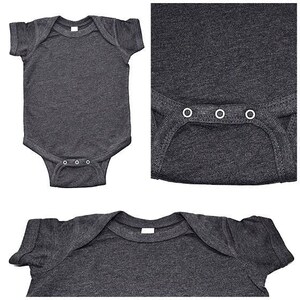 May include: A dark gray baby onesie with short sleeves and a snap closure. The onesie is made of a soft, comfortable fabric and has a heather gray color.