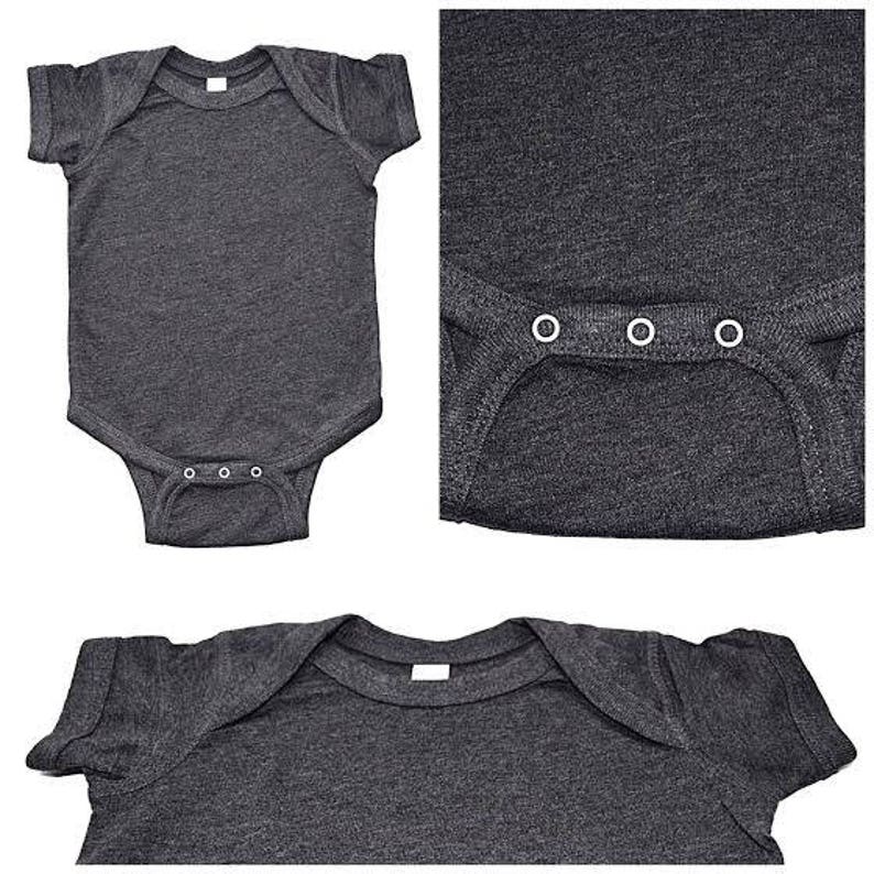 May include: A dark gray baby onesie with short sleeves and a snap closure. The onesie is made of a soft, comfortable fabric and has a heather gray color.