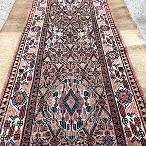 Puede incluir: Una alfombra larga y estrecha con un dise&ntilde;o persa tradicional. La alfombra es principalmente en tonos de rosa, rojo y azul, con intrincados patrones florales y geom&eacute;tricos. La alfombra tiene flecos en ambos extremos.