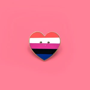 May include: A heart-shaped pin with a multi-colored stripe design. The stripes are red, white, pink, black, and blue. The pin has a smiling face.