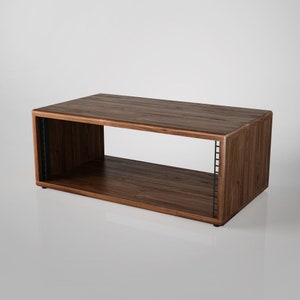 May include: A wooden rack with a dark brown finish and a single shelf. The rack has a rectangular shape and is made of solid wood.